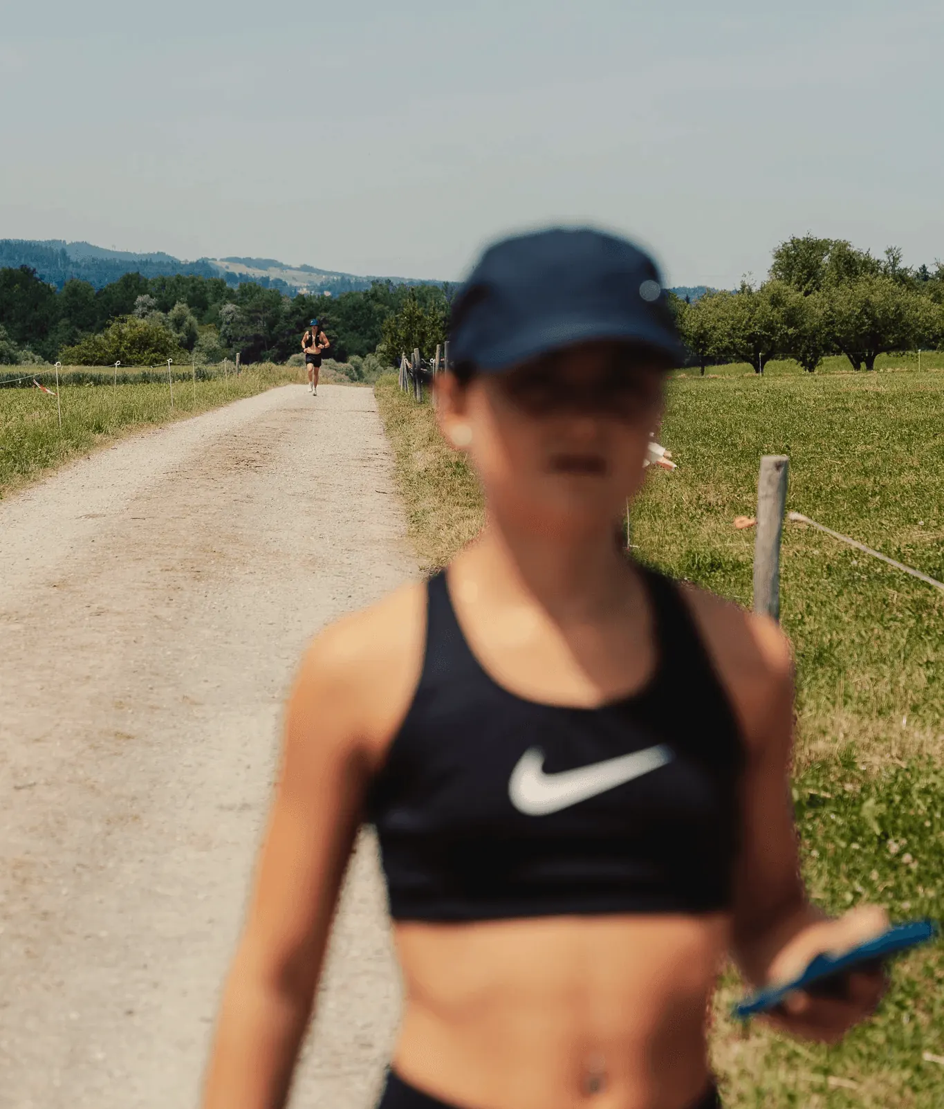 Una persona corre dritta verso la fotocamera su un sentiero di ghiaia